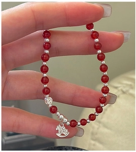 Détail du bracelet en argent S925 avec perles d'agate rouge, breloques cheval et pièce