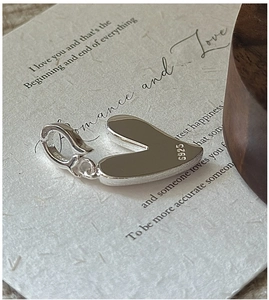 Gros plan du pendentif cœur en argent sterling S925 montrant le poinçon authentique