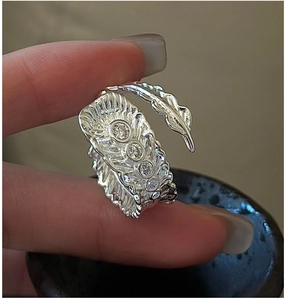 Detailed view of silver feather ring featuring four sparkling cubic zirconia stones