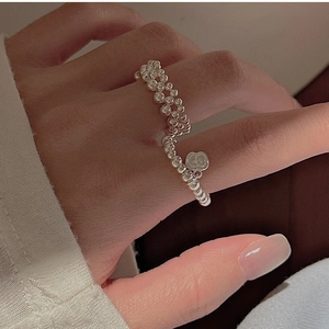 Detail of S925 sterling silver beaded rings with textured band and apple charm