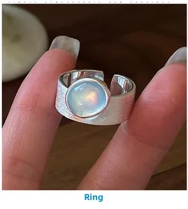 Macro shot of silver ring with brushed texture and blue moonstone center stone