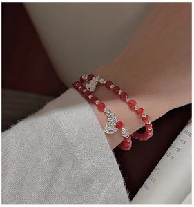 Gros plan du bracelet en argent 925 avec perles d'agate rouge et breloque cheval