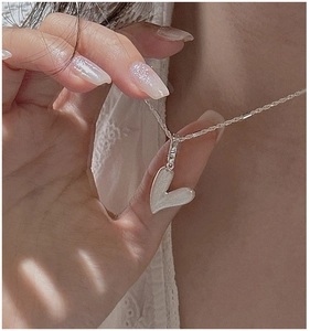 Détail du collier en argent s925 avec pendentif cœur blanc asymétrique sur mannequin