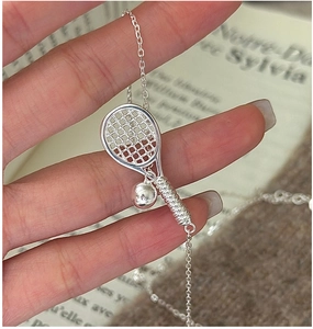 Close-up of S925 sterling silver tennis racket necklace with small ball pendant and O-chain