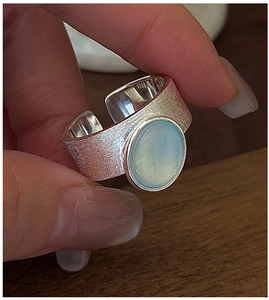 Detailed close-up of S925 sterling silver ring with etched finish and blue gemstone