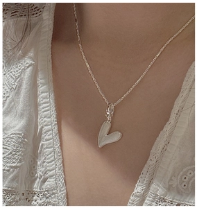 Détail du collier coeur en argent sterling S925 avec texture brossée vintage sur le cou