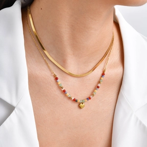 Layered gold snake chain necklace with colorful beads and a polished heart pendant