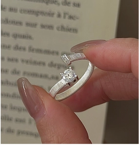 Macro detail of S925 sterling silver ring featuring silk texture and round white zircon