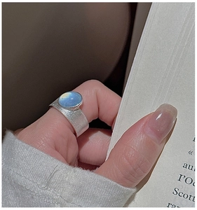 Detailed shot of a vintage S925 silver ring featuring hammered texture and a blue gemstone