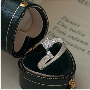 Detail of S925 sterling silver ring with round diamond in a green velvet heart box