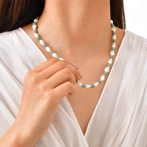 Detail view of ocean style beaded necklace with shells and turquoise beads worn on neck