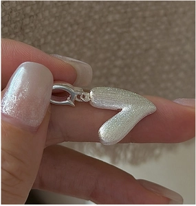 Détail du pendentif cœur en argent S925 avec texture brossée mate et fermoir mousqueton