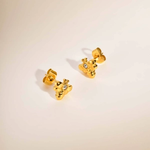 Detailaufnahme goldener Bienenohrstecker mit Zirkonia-Stein in minimalistischem Stil