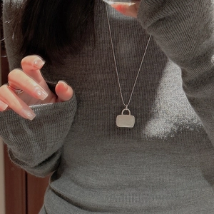 Minimalist S925 silver handbag pendant necklace on grey knit sweater background