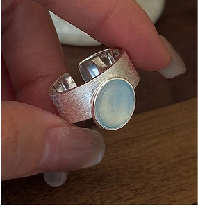 Macro detail of wide S925 silver ring with blue gemstone and frosted brushed texture