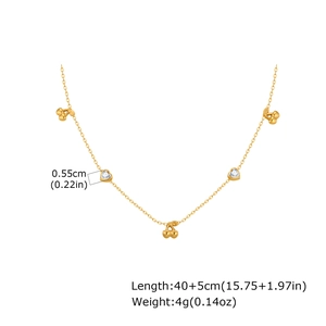Detail of golden heart-shaped white zircon and cherry bow necklace pendant