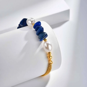 Détail de pierres de lapis-lazuli et perles avec chaîne dorée sur présentoir blanc