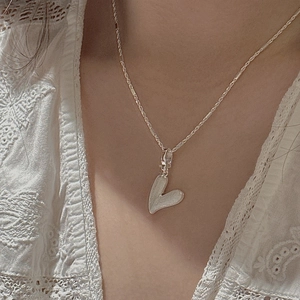 Collier cœur en argent S925 texturé vintage porté par un mannequin en haut dentelle