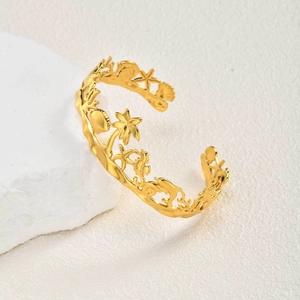 Détail du bracelet doré ajouré avec motifs de palmier, étoile de mer et coquillages