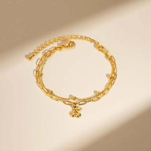 Détail du bracelet doré double épaisseur avec pendentif cerise et fermoir mousqueton