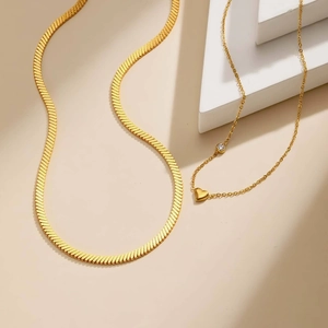 Layered gold herringbone chain necklace with heart pendant and sparkling zircon stone