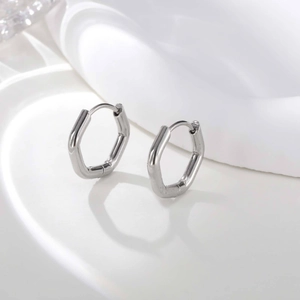 Polished silver geometric hexagonal U-shaped hoop earrings on a white minimalist display