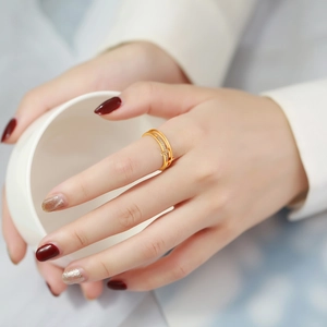 Bague double couche en acier doré sertie de zircons portée sur la main d'un modèle
