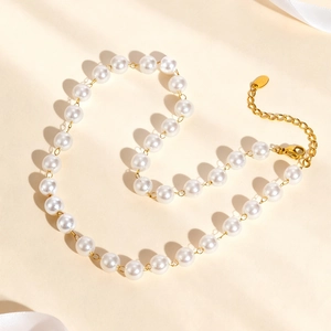 Close-up of golden pearl Y-necklace with lobster clasp and adjustable link chain detail