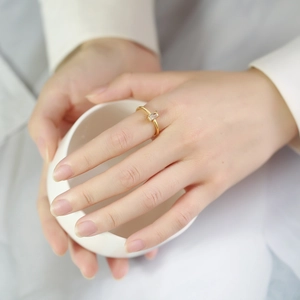 Close-up of a minimalist gold ring with rectangular zircon stone worn by a model