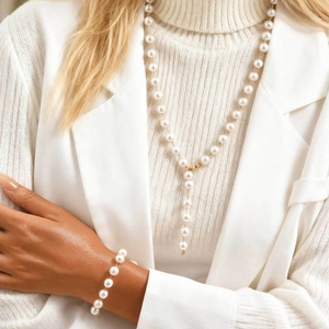 Minimalist gold Y-shaped pearl necklace and bracelet set shown on a female model