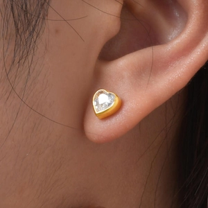 Detail of 18K gold plated heart stud earring with white zircon on ear