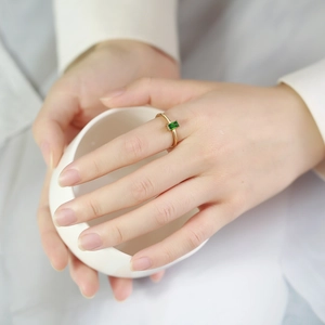 Detailed view of a gold ring featuring a rectangular green zircon stone and thin band