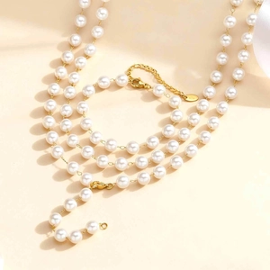 Elegant gold stainless steel Y-shaped necklace with white pearls in a layered minimalist design