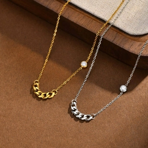 Close-up of minimalist gold and silver stainless steel chain necklace with zircon accent
