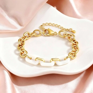 Detail of vintage gold-tone chain bracelet with white square links and lobster clasp