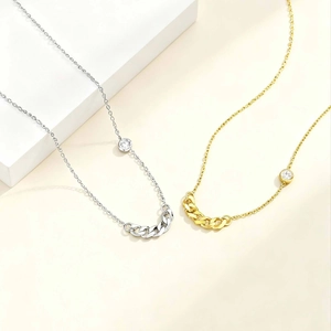 Macro shot of gold and silver minimalist chain necklaces with zircon pendants