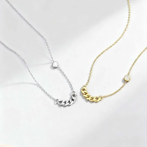 Macro detail of gold and silver stainless steel curb link necklaces with cubic zirconia
