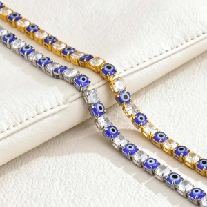 Detailed close-up of gold and silver Evil Eye tennis bracelets with blue and white zircon