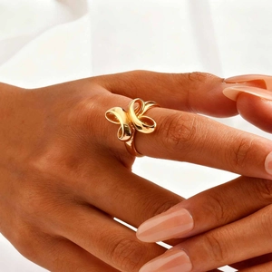 Minimalist gold bow knot ring with polished mirror finish on model's hand