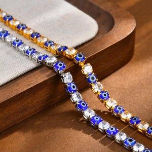 Gold and silver tennis bracelet set with sparkling white cubic zirconia and evil eye charms