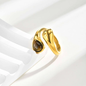Detailed macro view of gold-plated water-drop ring with natural tiger eye stone