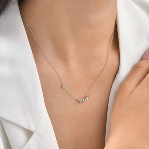Detail of silver stainless steel necklace with zircon and Cuban chain on model collarbone