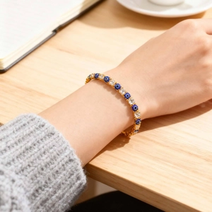 Detail view of gold evil eye bracelet with blue stones and zircon on a wrist