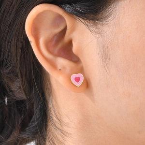 Gros plan d'un modèle portant une boucle d'oreille cœur en émail rose à double couche