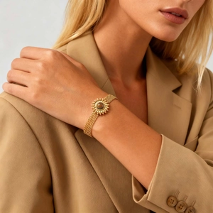 Bracelet en maille d'acier doré avec pierre œil de tigre soleil sur le poignet du mannequin