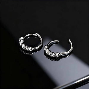 Gros plan détaillé de boucles d'oreilles torsadées argentées à texture métallique