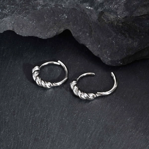 Détail du mécanisme de verrouillage et texture torsadée de la boucle d'oreille argentée