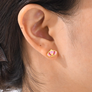 Gros plan d'un clou d'oreille couronne rose et violet avec une base dorée polie