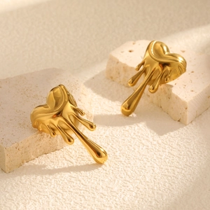 Boucles d'oreilles cœur liquide doré moderne sur pierre avec éclairage doux