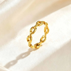 Macro shot of 18K gold chain ring with high polished finish on cream silk background